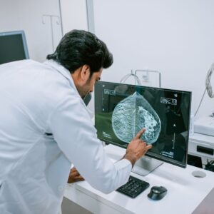 A doctor pointing to a brain scan on a screen