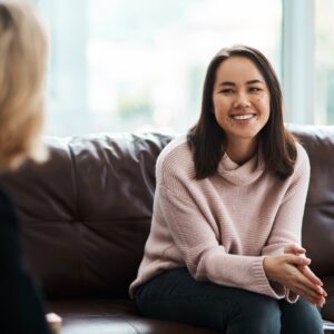 A woman smiling while speaking to her therapist
